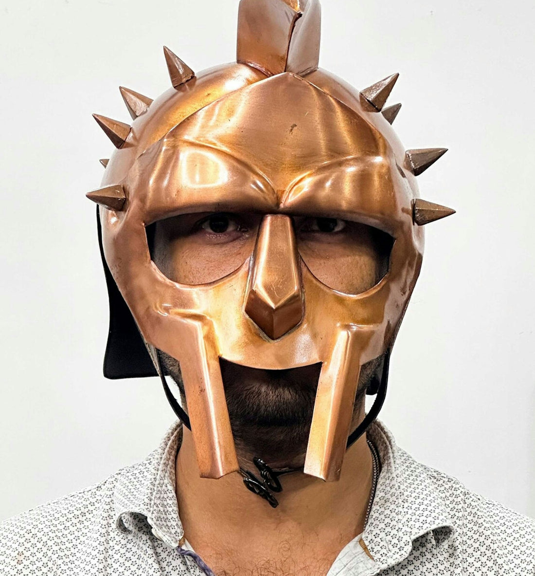 a man wearing a helmet with spikes on it