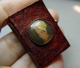 Uniikit korut miniatyylikirjalla ja nahkakansilla