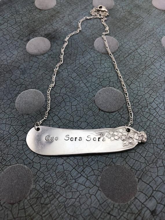 Hellulandian muistojen koruja - aterinkorut:  kaiverrettu sanonta, , veitsi